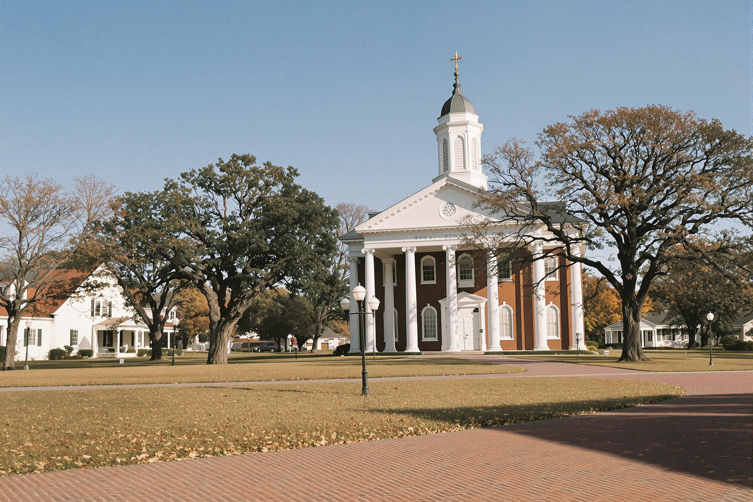A white-columned brick county courthouse on a green with old oaks